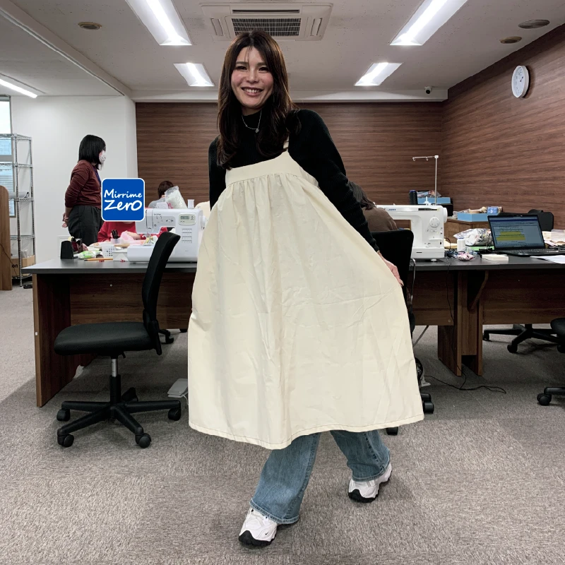 ワンピースを広げて試着している職員、正面