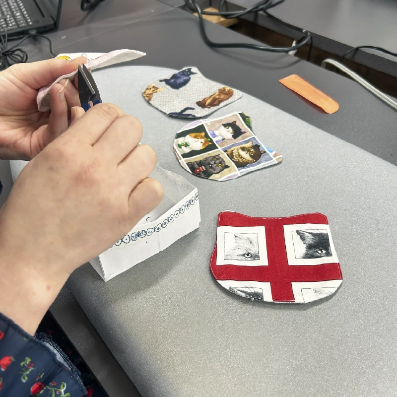 猫柄コースターの淵を利用者さんが確認している様子