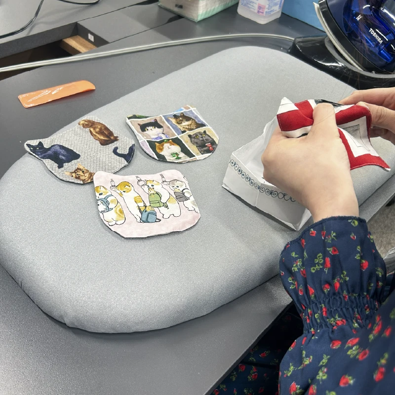 複数の猫柄コースターを並べて細かく調整する利用者さん
